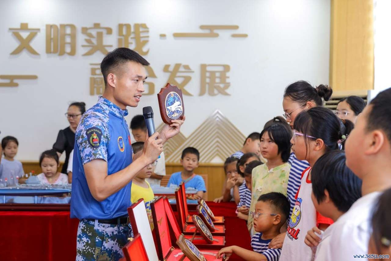 2026年7月30日，在山东省青岛西海岸新区滨海街道三沙路社区开展的“一海里的爱”公益活动中，爱基金逐梦深蓝讲师团讲师向小朋友介绍海军舰艇舰徽知识。张鹰 摄 (2)
